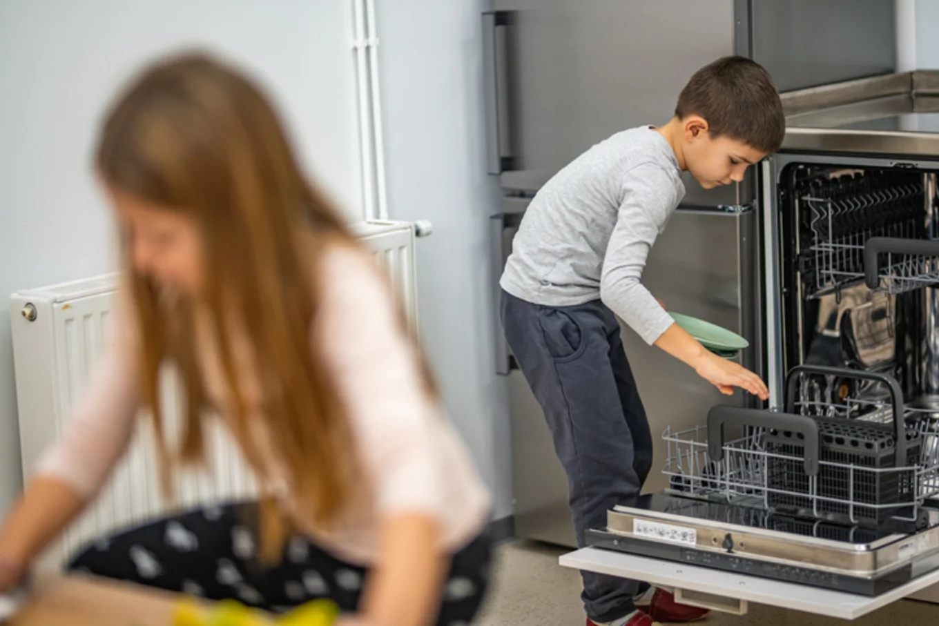Bauarena Küchenwelt: Kinder räumen Geschirrspüler aus