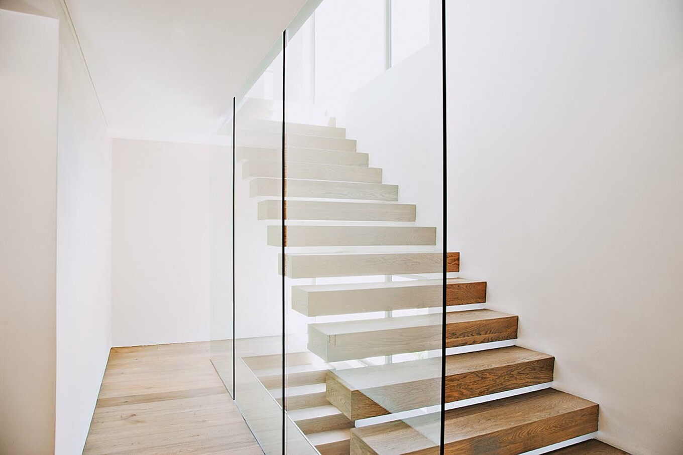 Treppen in Kombination mit unterschiedlichen Materialien wie Glas und Holz sind ein Hingucker im Haus